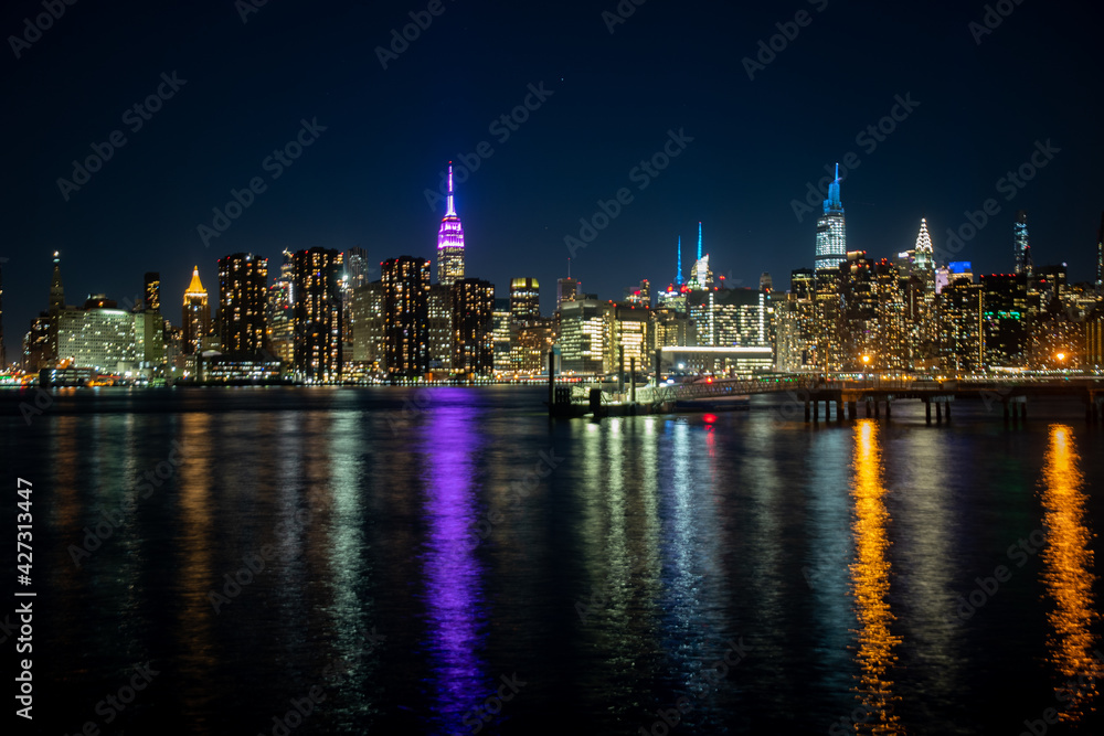 The lights of Midtown Manhattan reflected into the East River at night