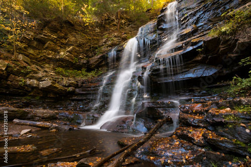 colorful autumn foliage with calming cascading waterfall in Pennsylvania.