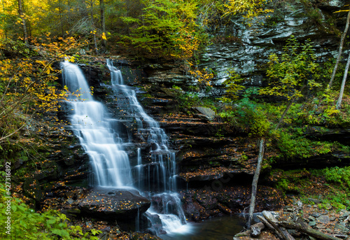 colorful autumn foliage with calming cascading waterfall in Pennsylvania.