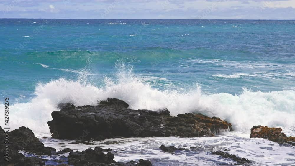 Blue Waves of the Pacific Ocean Beats Oahu Island Volcanic Cliffs. Turquoise water color. Clear sunny day. Archipelago Hawaii. DCI 4k. Slow Motion.