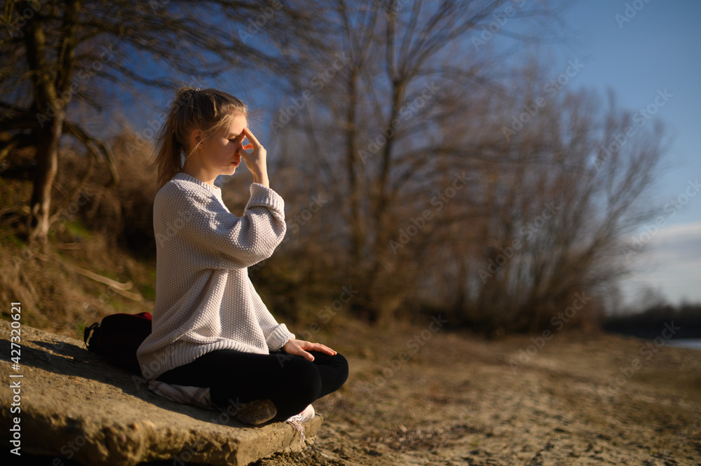 Practice of meditation and interaction with nature. Girl near river