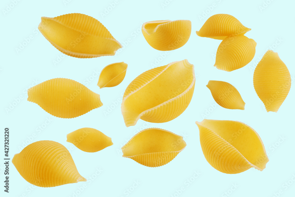 Flying raw striped shell pasta isolated on a light background, italian national cuisine traditional uncooked ingredient. Flying raw striped shell pasta isolated on a light background, italian national cuisine traditional uncooked ingredient.