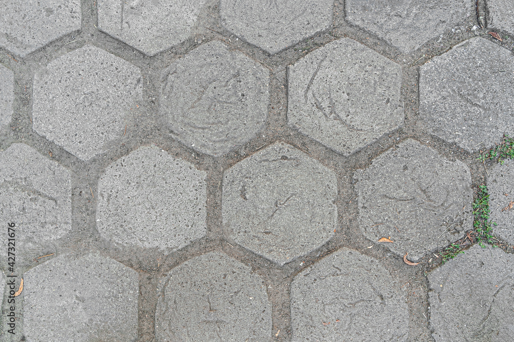 abstract background of tiled walkway in the park with grass punching between the joints close up abstract background of tiled walkway in the park with grass punching between the joints close up