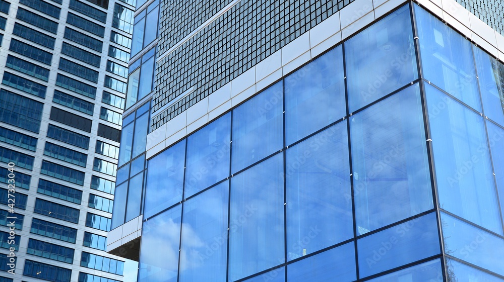 Glass clad facade of a modern building covered in reflective plate glass. Glass clad facade of a modern building covered in reflective plate glass.
