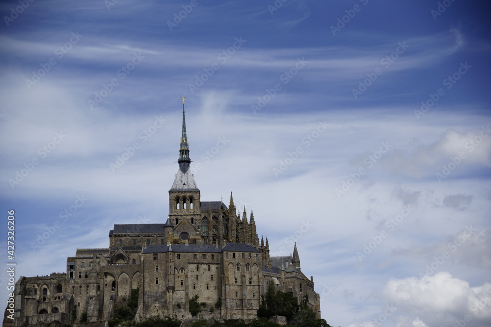 Le Mont-Saint-Michel mit wolkigem Himmel bei Ebbe
