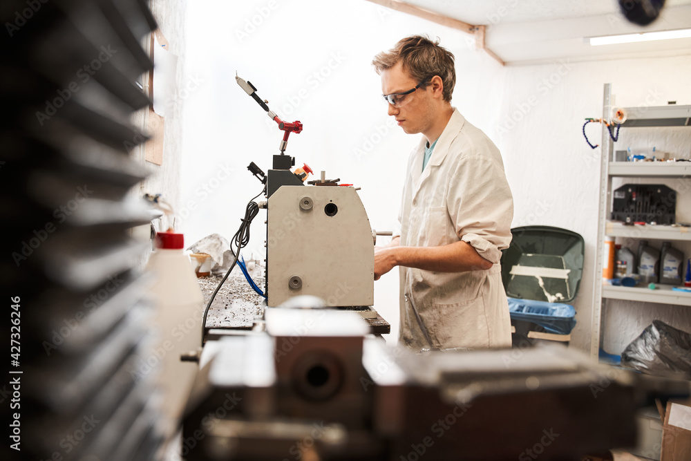 Man engineer standing at the special machine and working while developing