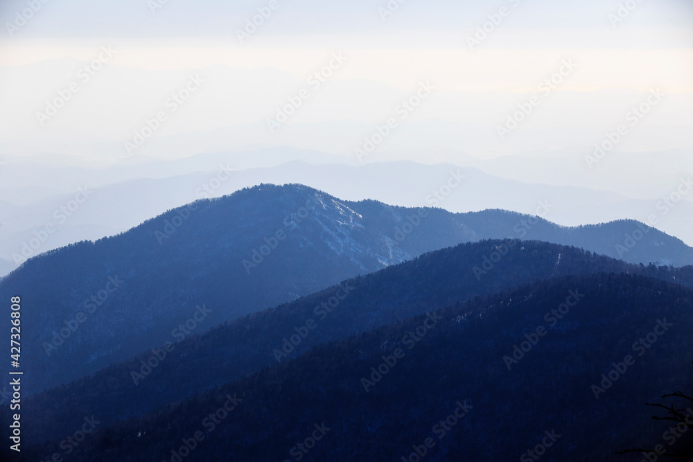 Travel to the Primorsky region. Silhouettes of distant snowy mountains. Mountain tourism. Travel to the Primorsky region. Silhouettes of distant snowy mountains. Mountain tourism.