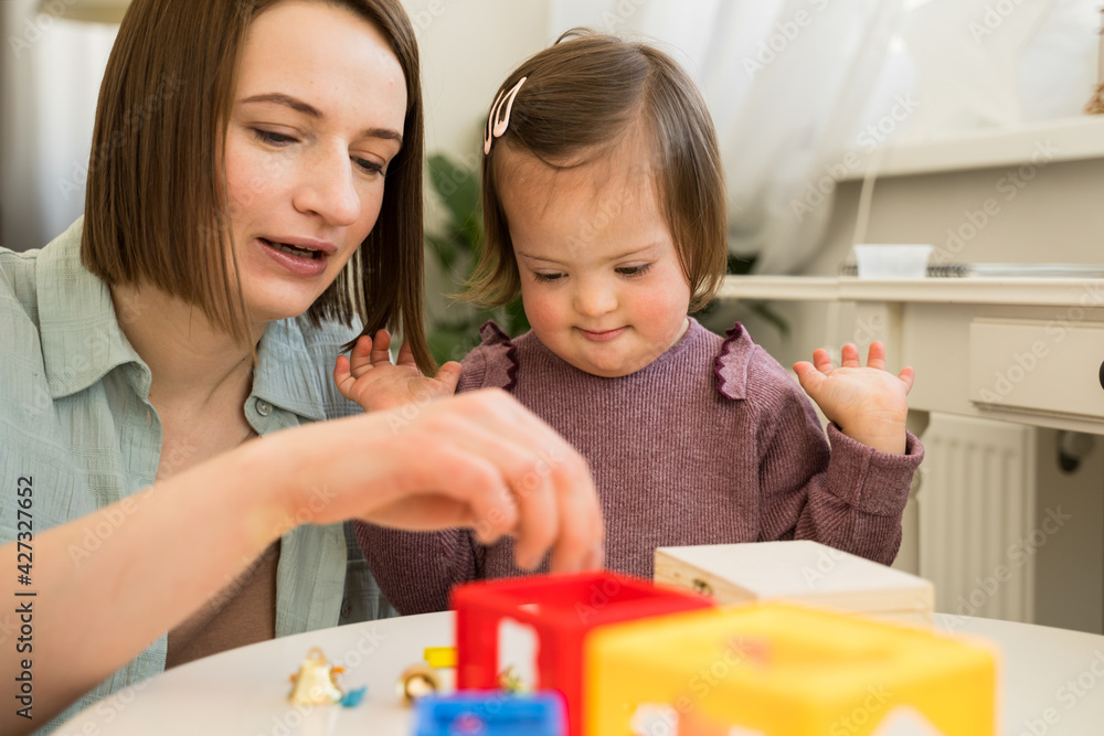 Down syndrome girl having game therapy with her mother Down syndrome girl having game therapy with her mother