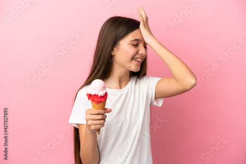 Little girl with a cornet ice cream over isolated pink background has realized something and intending the solution