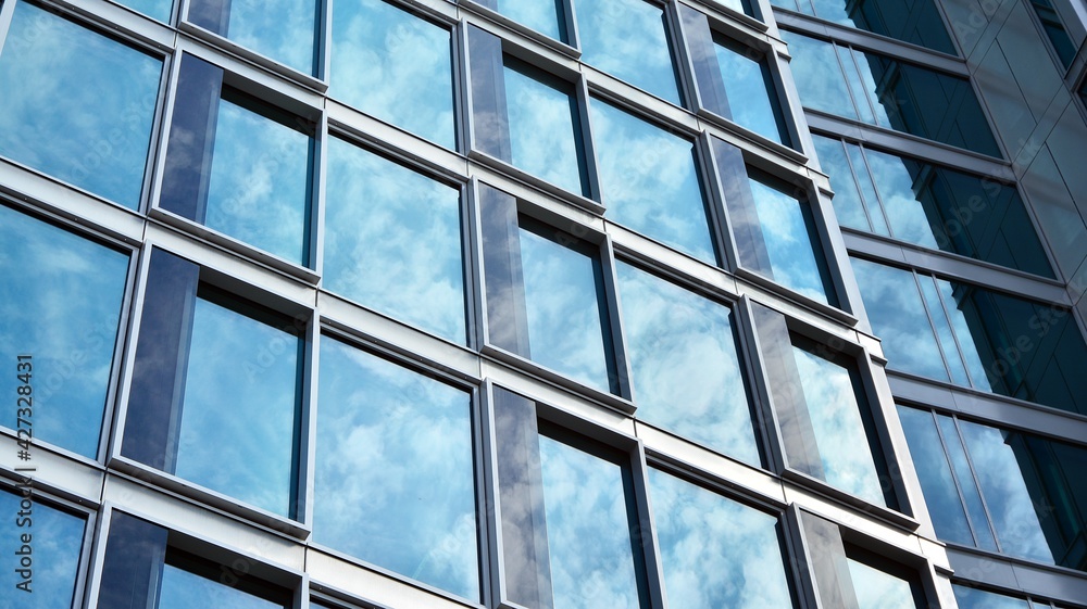 Glass clad facade of a modern building covered in reflective plate glass. Glass clad facade of a modern building covered in reflective plate glass.