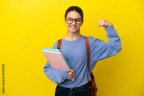 Student kid woman over isolated yellow background doing strong gesture