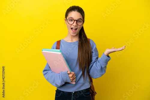Student kid woman over isolated yellow background with shocked facial expression