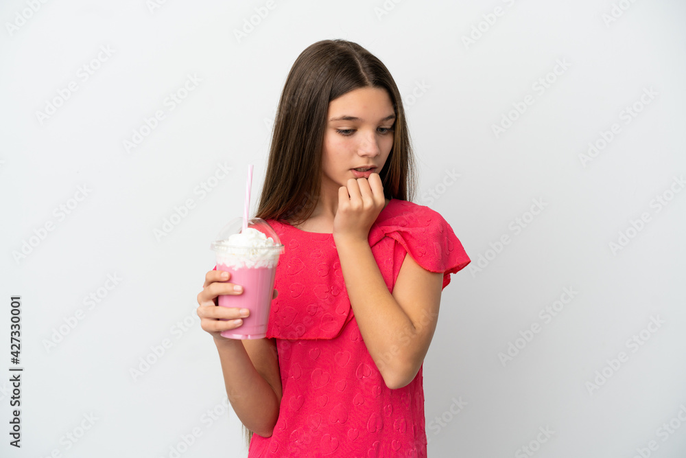 Little girl with strawberry milkshake over isolated white background having doubts