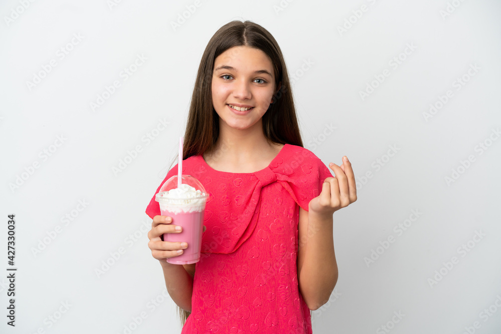 Little girl with strawberry milkshake over isolated white background making money gesture Little girl with strawberry milkshake over isolated white background making money gesture