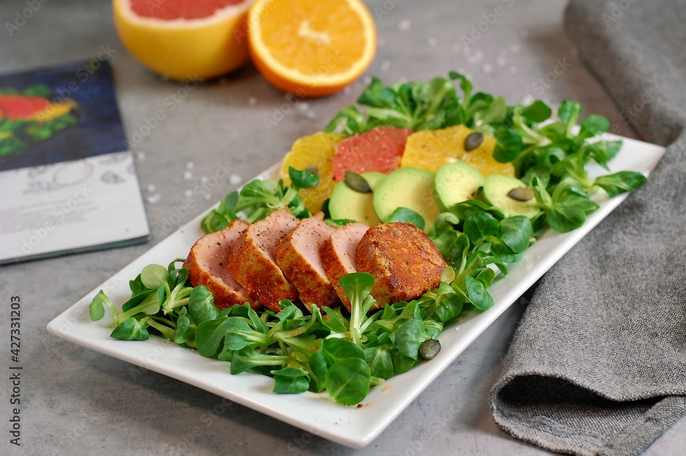 Fresh salad with lettuce, orange, grapefruit, avocado a port fillet on white plate Fresh salad with lettuce, orange, grapefruit, avocado a port fillet on white plate
