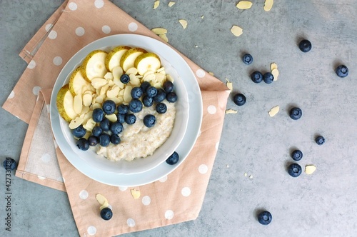 Creamy buckwheat porridge with pear, blueberry and almond in white bowl