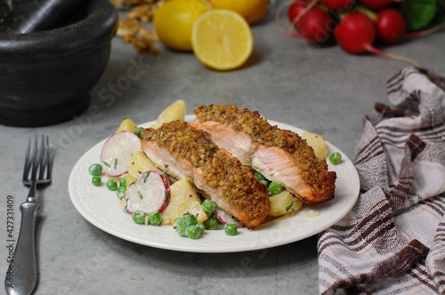 Fresh potato salad with peas, radish and roasted salmon with walnut crust