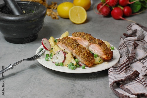 Fresh potato salad with peas, radish and roasted salmon with walnut crust