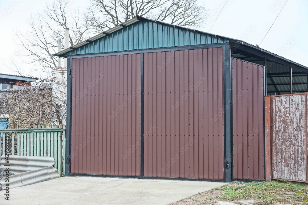 facade of a private garage with closed brown metal gates on the street facade of a private garage with closed brown metal gates on the street