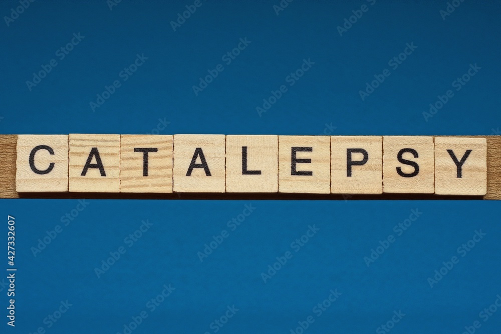 gray word catalepsy in small square wooden letters with black font on a blue background gray word catalepsy in small square wooden letters with black font on a blue background