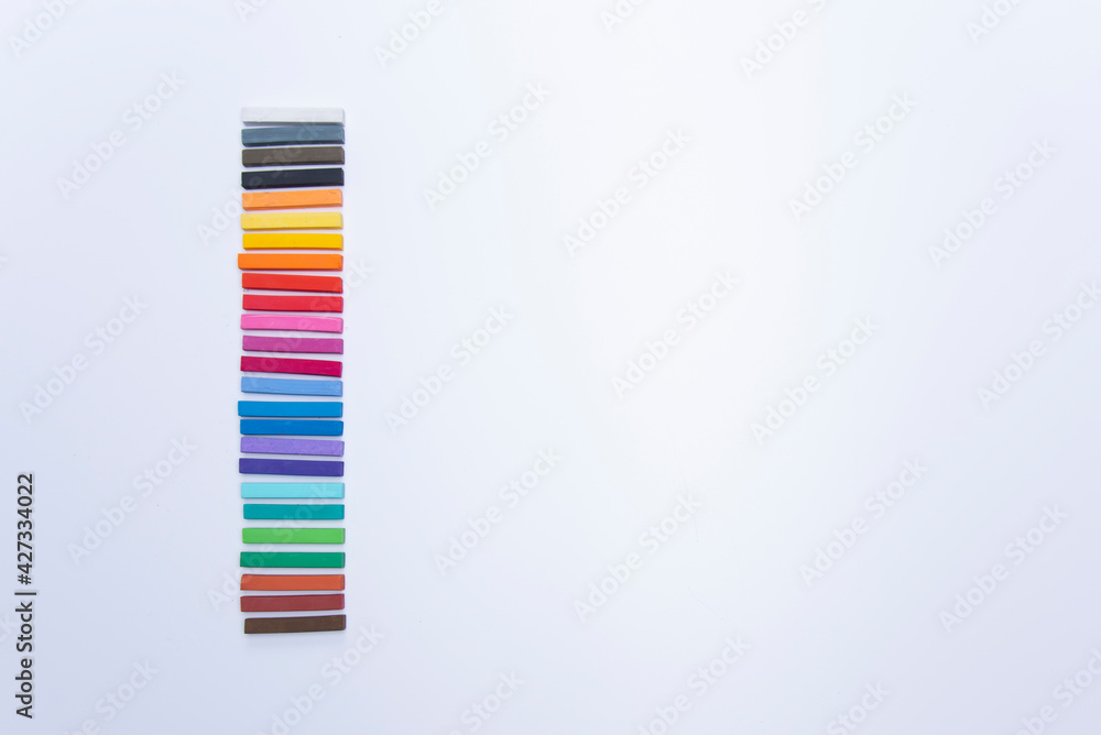 GROUPS OF COLORED CHALKS IN PILES ON A WHITE BACKGROUND GROUPS OF COLORED CHALKS IN PILES ON A WHITE BACKGROUND