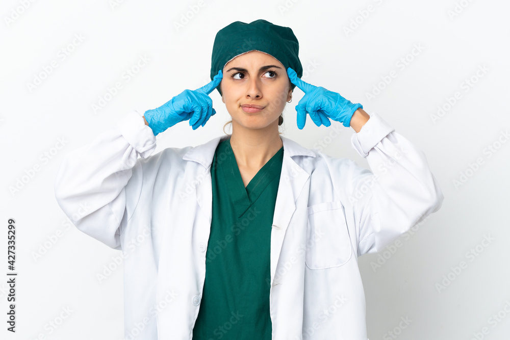 Naklejka premium Surgeon caucasian woman isolated on white background having doubts and thinking
