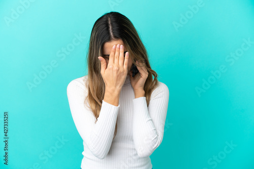Young caucasian woman using mobile phone isolated on blue background with tired and sick expression