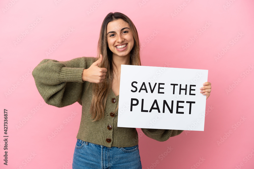 Young caucasian woman isolated on pink background holding a placard with text Save the Planet with thumb up Young caucasian woman isolated on pink background holding a placard with text Save the Planet with thumb up