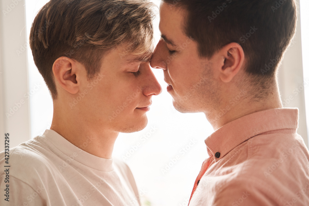 Boy keeping his eyes closed while standing at the kitchen with his boyfriend Boy keeping his eyes closed while standing at the kitchen with his boyfriend