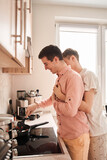 Couple embracing and preparing food together, while spending time in the kitchen