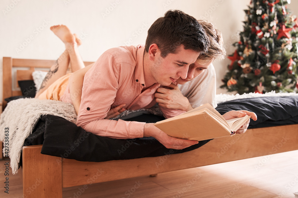 Homosexual people reading book on the bed Homosexual people reading book on the bed