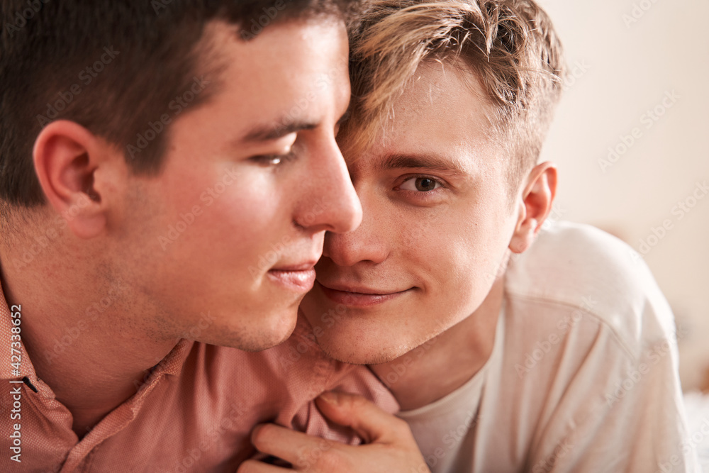 Passionate homosexual couple laying at the bed while spending romantic weekend Passionate homosexual couple laying at the bed while spending romantic weekend