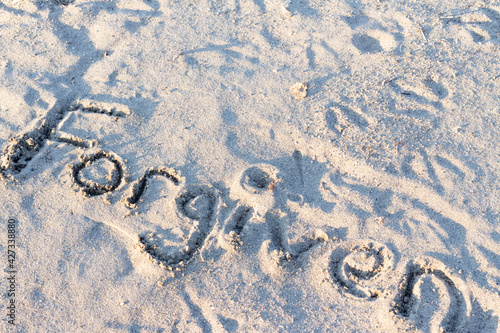 word forgiven written in sand