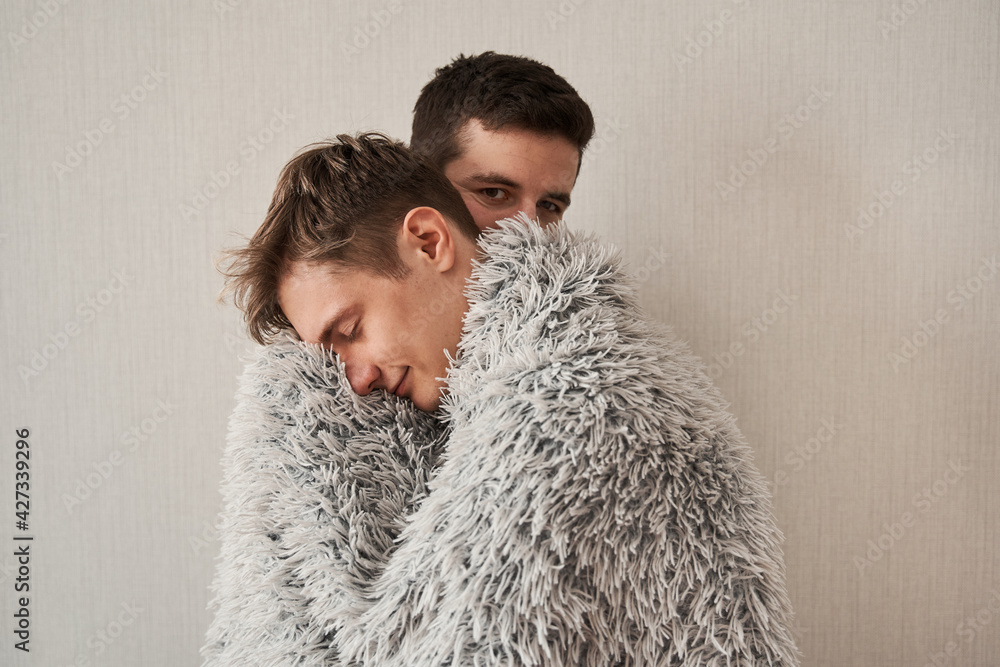 Homosexual man embracing his boyfriend at the balcony at home Homosexual man embracing his boyfriend at the balcony at home