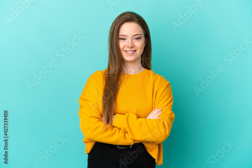 Teenager girl over isolated blue background keeping the arms crossed in frontal position