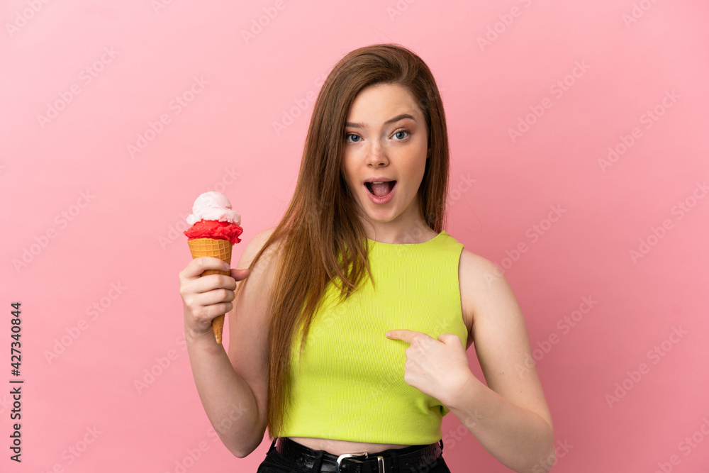 Teenager girl with a cornet ice cream over isolated pink background with surprise facial expression Teenager girl with a cornet ice cream over isolated pink background with surprise facial expression