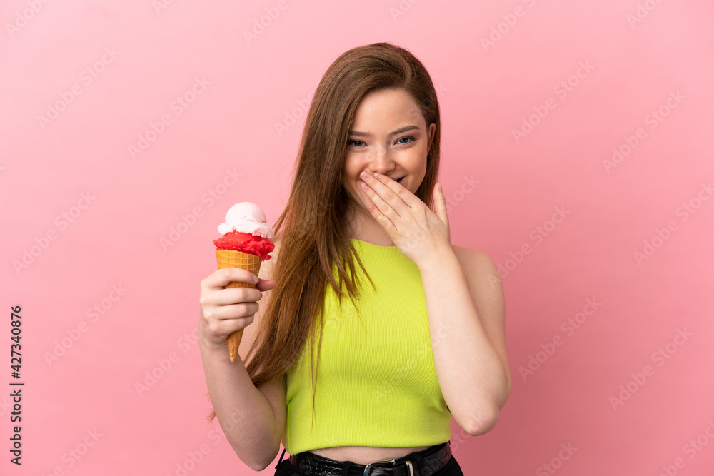 Teenager girl with a cornet ice cream over isolated pink background happy and smiling covering mouth with hand Teenager girl with a cornet ice cream over isolated pink background happy and smiling covering mouth with hand