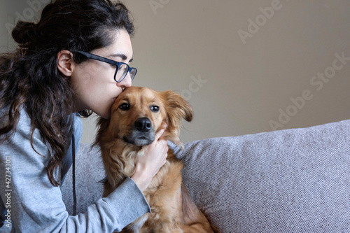 A young woman kisses her dog. Animal love. Copy space.