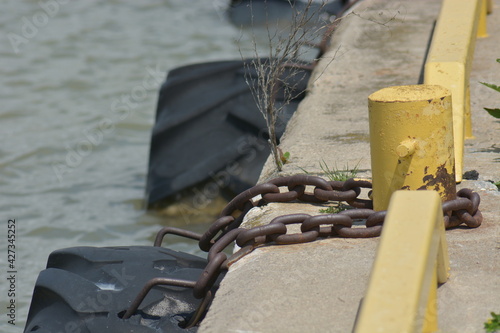 Chain Holding Tire In Harbor