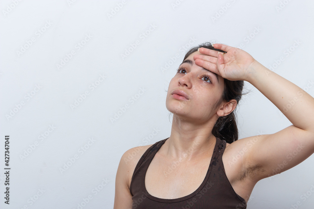 Brown tank top woman on white background with hair tied sweaty and tired