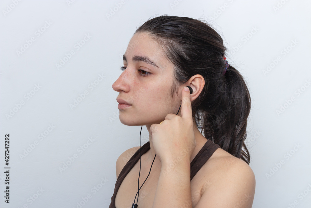 Brown tank top woman on white background with hair tied with cellphone and headset Brown tank top woman on white background with hair tied with cellphone and headset