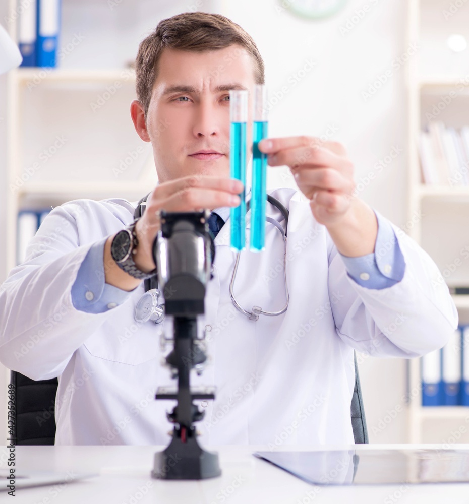 Male doctor looking at lab results in hospital Male doctor looking at lab results in hospital