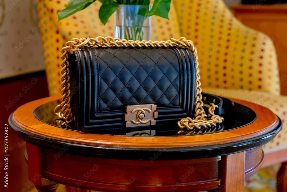 Venice, Italy Jun8 2019: black leather Chanel bag Chanel boy 8 inch. Classic  luxury style gold chain foto de Stock | Adobe Stock