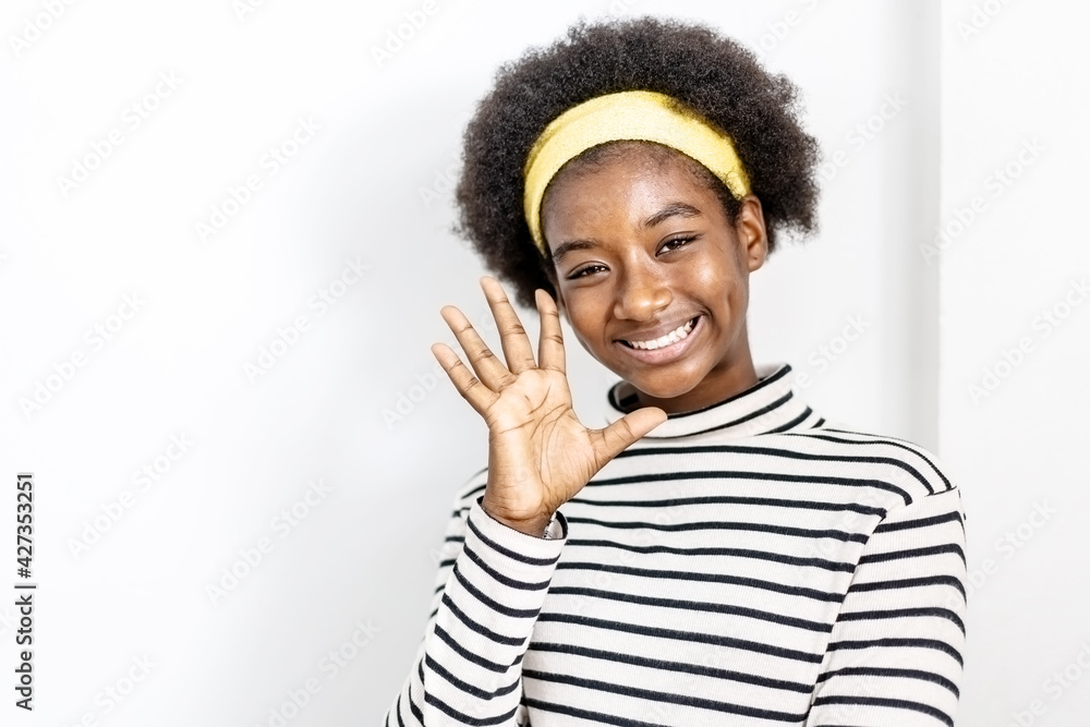 Cute african american girl wearing casual clothes waving saying hello happy and smiling, friendly welcome gesture Cute african american girl wearing casual clothes waving saying hello happy and smiling, friendly welcome gesture
