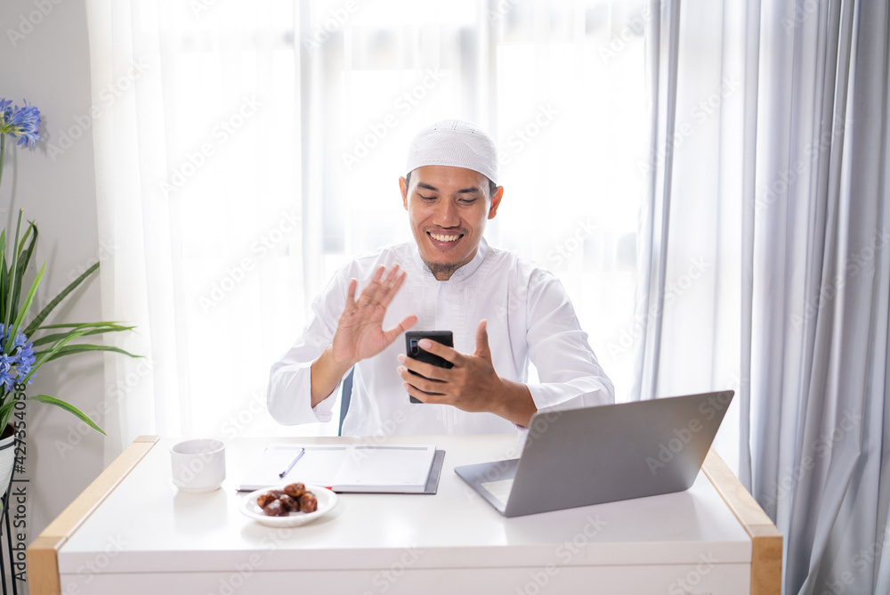 busy asian muslim businessman make a video call using his mobile phone busy asian muslim businessman make a video call using his mobile phone