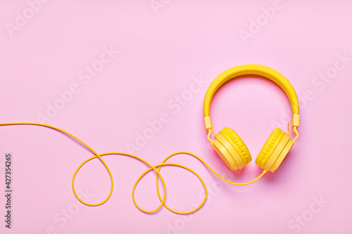 Yellow headphones on pink background. Minimal Music concept, flat lay, copy space © colnihko