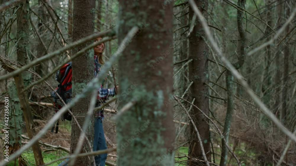 Happy woman hiking in wood. Female traveler walking in fairytale forest Happy woman hiking in wood. Female traveler walking in fairytale forest