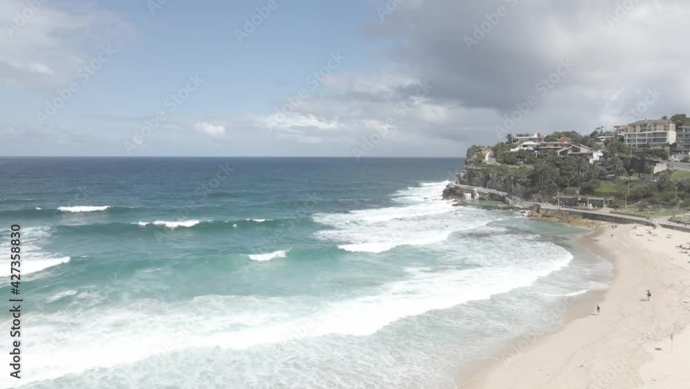 Aerial View Of Bronte Beach Coastline with Foamy Ocean Waves And Tourists In Eastern Suburbs, Sydney, New South Wales, Australia - drone shot Aerial View Of Bronte Beach Coastline with Foamy Ocean Waves And Tourists In Eastern Suburbs, Sydney, New South Wales, Australia - drone shot