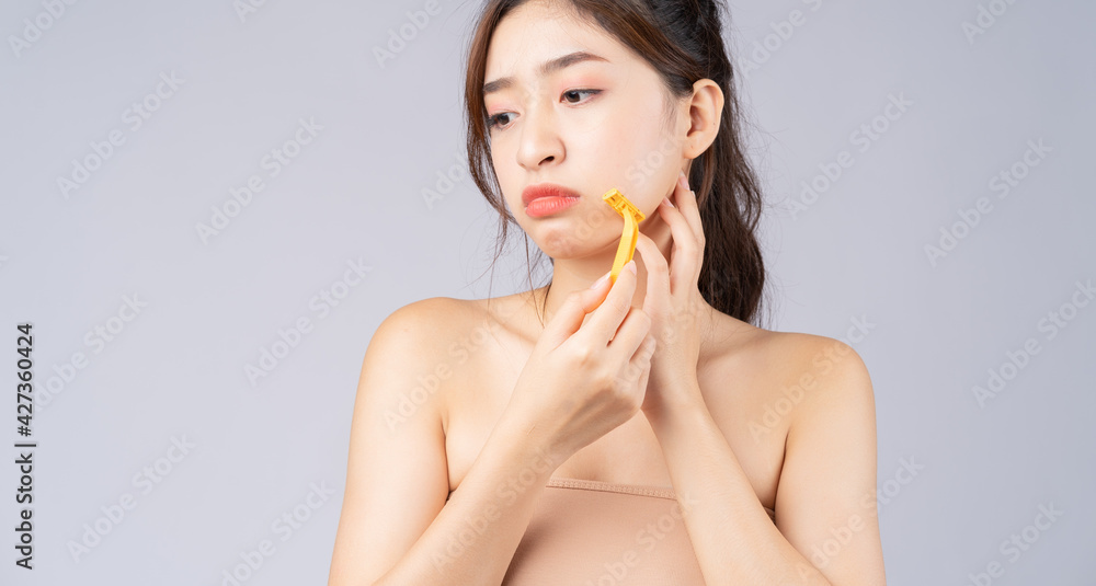 Φωτογραφία Young Asian girl worried about facial hair
