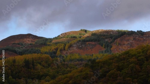 Timelapse of rolling clouds and autumn colours over a Highland Perthshire Forest. Filmed near St. Fillans, Scotland. photo